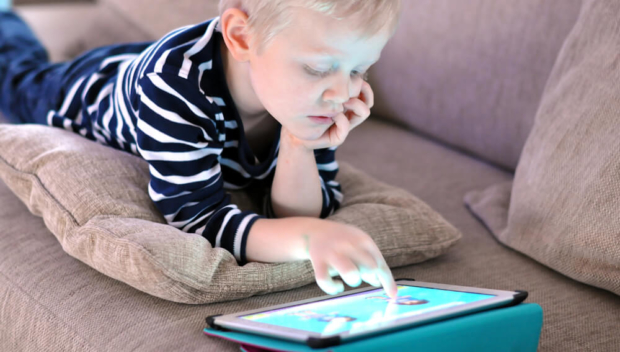 Garoto animado jogando jogo no celular. dois pais ajudando o filho